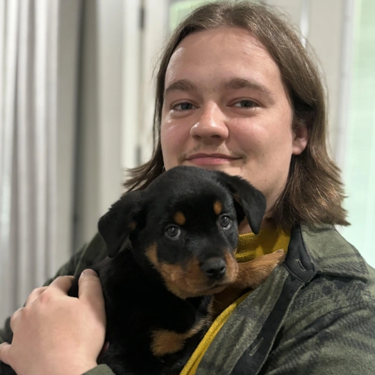 A man with a puppy in his arm